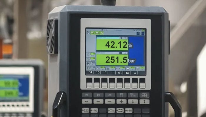 Close-up of an industrial digital pressure controller displaying 42.12% and 251.5 bar on a color screen with multiple control buttons.